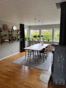 a kitchen and dining room with a table and chairs at Enplansvilla med pool in Tyresö