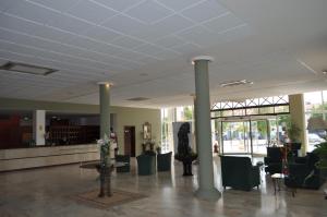 a lobby with columns and chairs and a table at Hotel Heredero in Olivenza