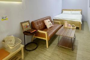 a living room with a couch and a bed at 旅人路過時民宿 in Hsi-lo