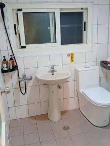 a bathroom with a sink and a toilet and a window at 旅人路過時民宿 in Hsi-lo +15 photos