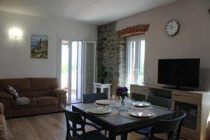 a living room with a table with chairs and a tv at CASA K2 - Lago Maggiore in Castelveccana
