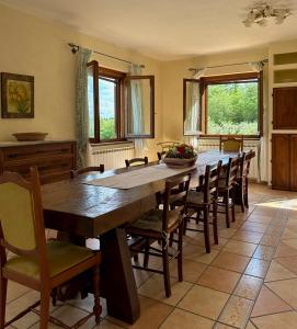 a dining room with a large wooden table and chairs at La Casa nel Bosco in Arezzo