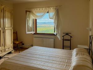 a bedroom with a large bed and a window at La Casa nel Bosco in Arezzo