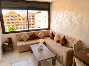 a living room with a couch and a large window at Nador Skyline Al Matar in Nador +22 photos