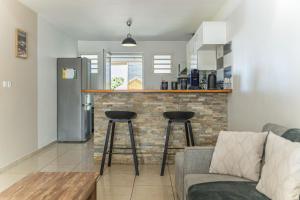a kitchen with a couch and two bar stools at Villa Mascareignas - Le Tampon in Le Tampon