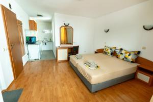 a bedroom with a large bed and a kitchen at Hotel Aia Kavatsi in Sozopol