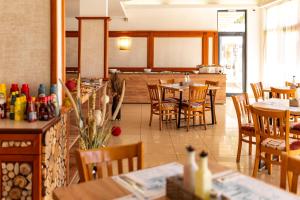 a restaurant with tables and chairs in a room at Hotel Pautalia in Sunny Beach