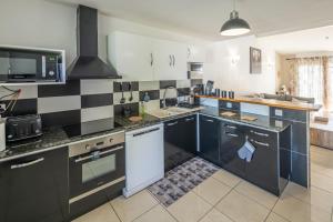 a kitchen with black and white tiles on the wall at Villa Mascareignas - Le Tampon in Le Tampon +20 photos