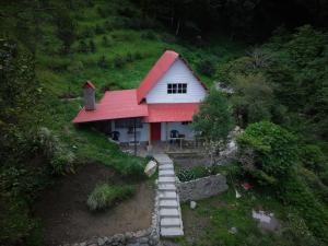 a house with a red roof on a hill at Cabaña El Cafetal in Valle Hornito