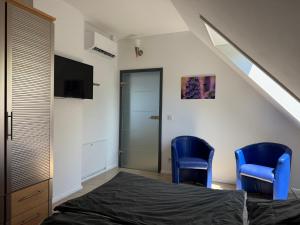 a bedroom with two blue chairs and a bed at Flat 39 in Wiehl