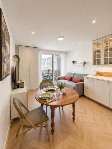 a kitchen and living room with a table and a couch at Méva in Courseulles-sur-Mer