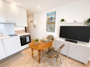 a small kitchen with a table and a tv in it at Méva in Courseulles-sur-Mer