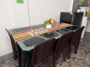 a glass table with chairs and a table with flowers on it at Itawis Resort - Ivanna's Room in Silang