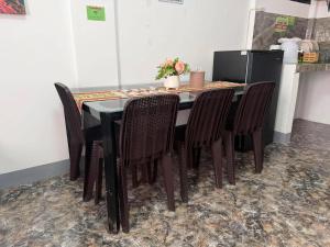 a dining room table with chairs and a refrigerator at Itawis Resort - Ivanna's Room in Silang +5 photos