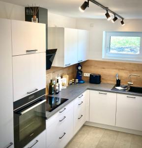 a kitchen with white cabinets and a sink at Alpen Liebe Prem in Prem