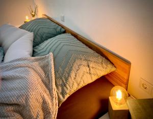 a bed with a wooden head board with a candle on a table at Alpen Liebe Prem in Prem