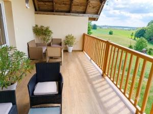 a balcony with chairs and tables and a view at Łapacz Mazurskich Chwil in Orzysz