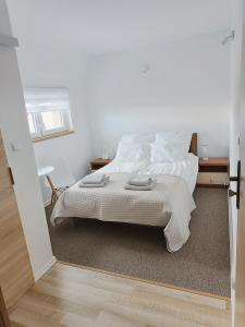 a bedroom with a bed with white sheets and a window at Łapacz Mazurskich Chwil in Orzysz +9 photos