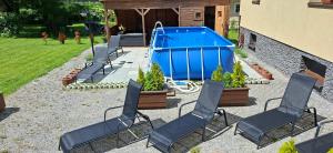 a group of chairs and a swimming pool at Vila Pohoda Javorníky s rozľahlým pozemkom in Makov