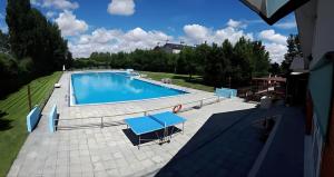 a large swimming pool with a blue table on a patio at Hotel Lasa Sport in Valladolid