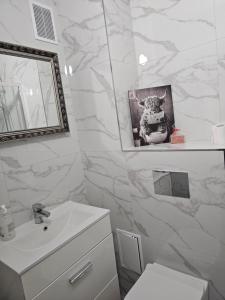 a white bathroom with a sink and a mirror at Blick auf die Kirche in Wschowa +9 photos