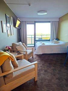 a large hotel room with a bed and a window at Huone upealla järvimaisemalla in Ikaalinen +1 photo