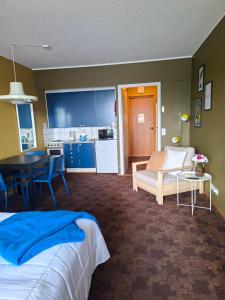 a bedroom with a bed and a table and a kitchen at Huone upealla järvimaisemalla in Ikaalinen
