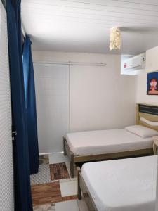 a small room with two beds and a window at Summer House in Jijoca de Jericoacoara