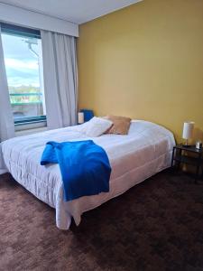 a bedroom with a large bed with a window at Huone upealla järvimaisemalla in Ikaalinen