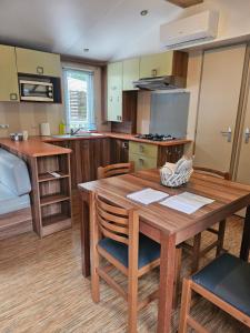 a kitchen with a wooden table and chairs in a room at camping des 7 fonts in Agde