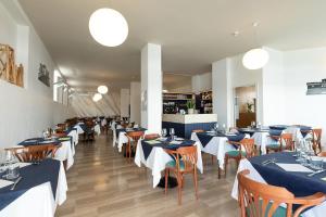 a restaurant with tables and chairs with blue and white tables at Hotel Paradiso in Senigallia