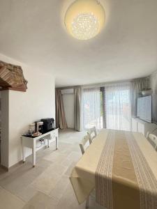 a room with a large bed with a table and a television at Relax House Sardara in Sardara