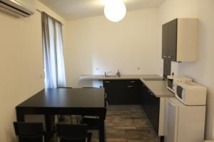 a small kitchen with a table and a microwave at Etablissements Coulon - Begles in Bègles