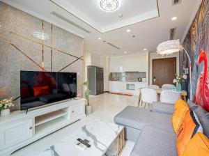 a living room with a couch and a television at The Fermin Premium Studios in Ho Chi Minh City
