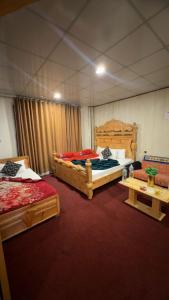 a room with two beds and two tables in it at Malam jabba Hotel reservation in Swat