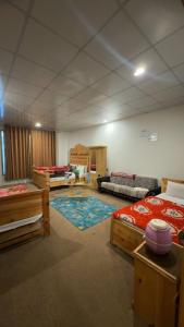 a large room with several beds and a rug at Malam jabba Hotel reservation in Swat