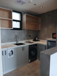 a kitchen with a sink and a washing machine at wifad Hotel in Al Namas