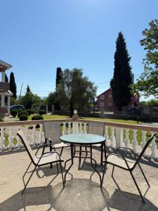 a table and two chairs sitting next to a fence at Apartments Ana - Airport shuttle option in Podgorica