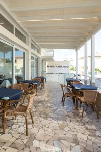 a patio with tables and chairs in a building at Hotel Paradiso in Senigallia