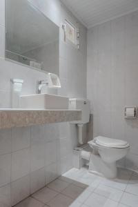 a white bathroom with a sink and a toilet at Domus Alta in Tsilivi