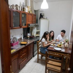 a group of people sitting at a table in a kitchen at Backpackers Durres in Durrës