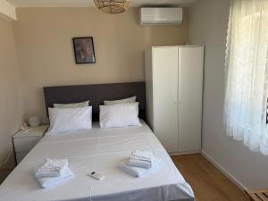 a bedroom with a white bed with towels on it at Greek sensation in Zagora +155 photos