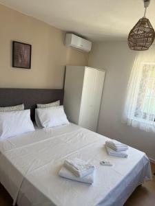 a bedroom with a white bed with two towels on it at Greek sensation in Zagora
