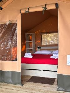 a bed in a tent with a red mattress at GLAMPING by SUNBEAM in Leporano Marina