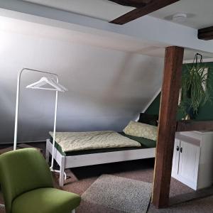 a bedroom with a bunk bed and a chair at Dachstübchen mit 2 Zimmern in Boizenburg