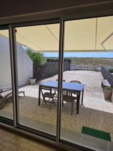 a glass window of a patio with a table at directe plage à moins de 100m in La Turballe