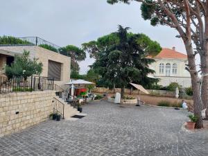 ein Innenhof mit einem Haus, einem Baum und einem Gebäude in der Unterkunft Eagles Nest Guesthouse- Rose Lily Suite 2 in Ḩaşrūn al Jadīdah