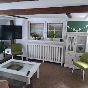 a living room with a tv and a coffee table at Dachstübchen mit 2 Zimmern in Boizenburg