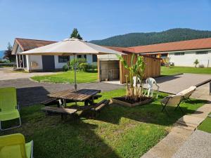 a picnic table and chairs in front of a house at La Clémentine in Vagney