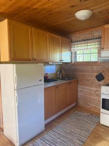 a kitchen with a white refrigerator and wooden cabinets at Hafslo hytteutleige Straumane in Luster